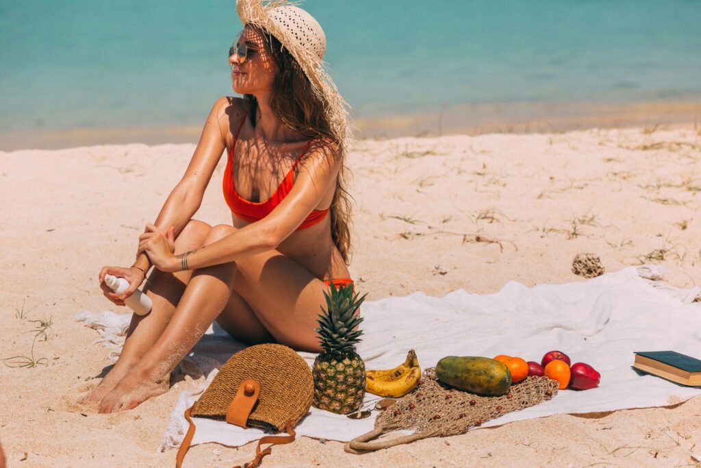 A woman sunbathing on a tropical beach surrounded by fruits, using sun protection lotion. Ideal summer leisure scene.
