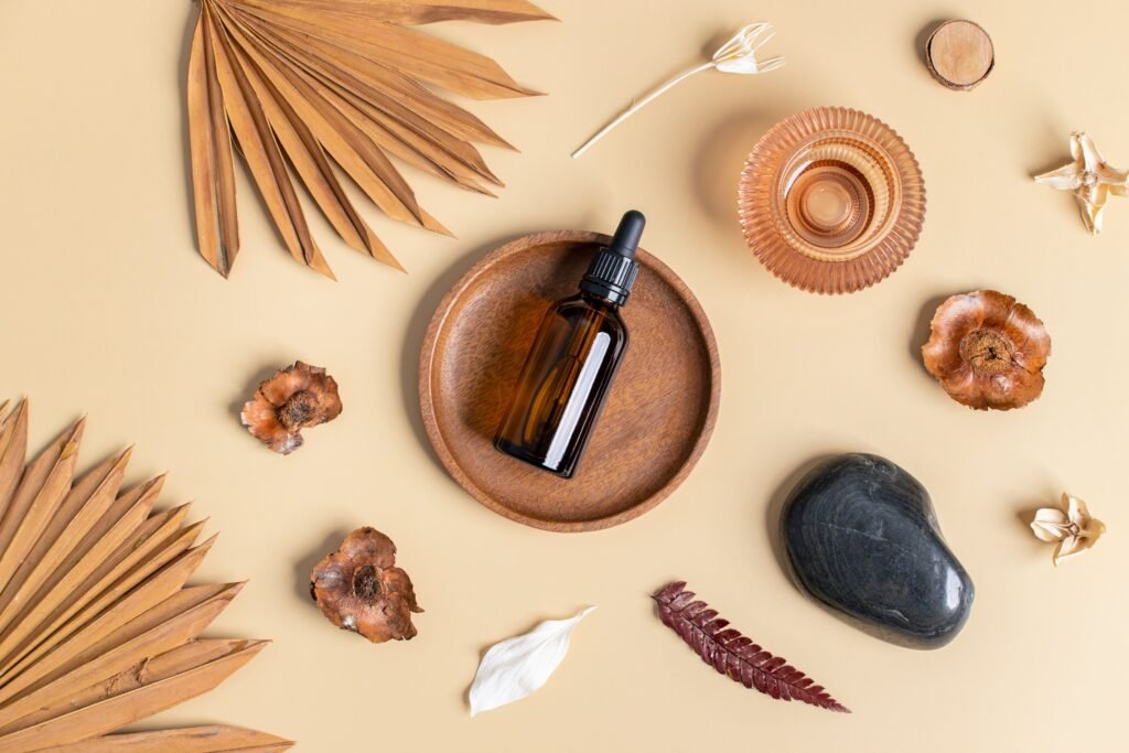 Flat lay of essential oil bottle with natural elements on a beige background, promoting wellness and relaxation.