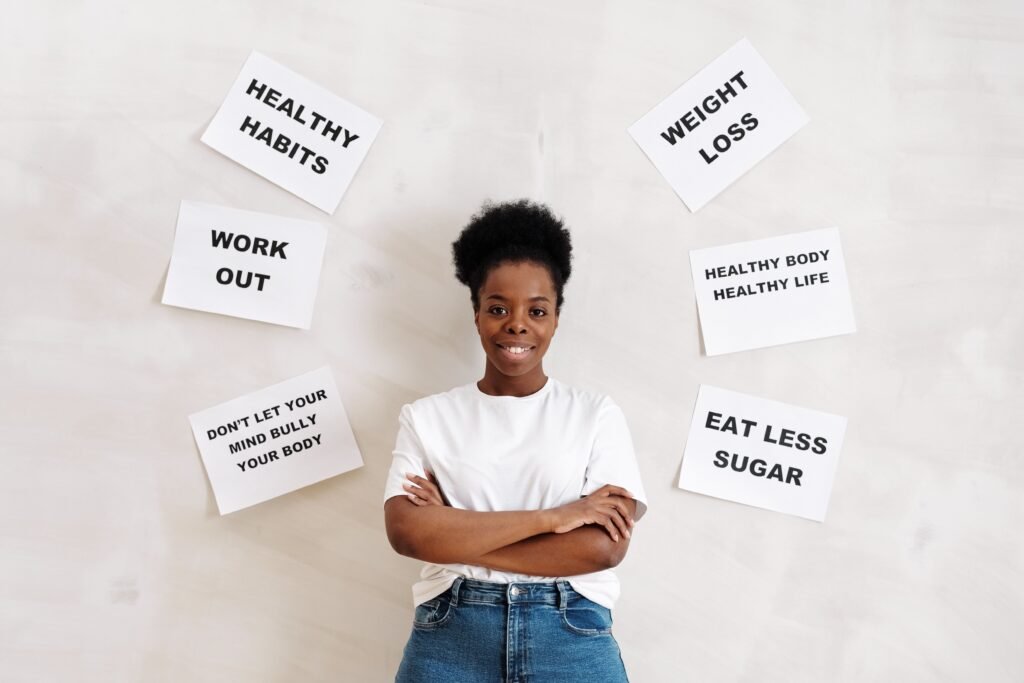Confident woman poses with motivational health messages on the wall for wellbeing.