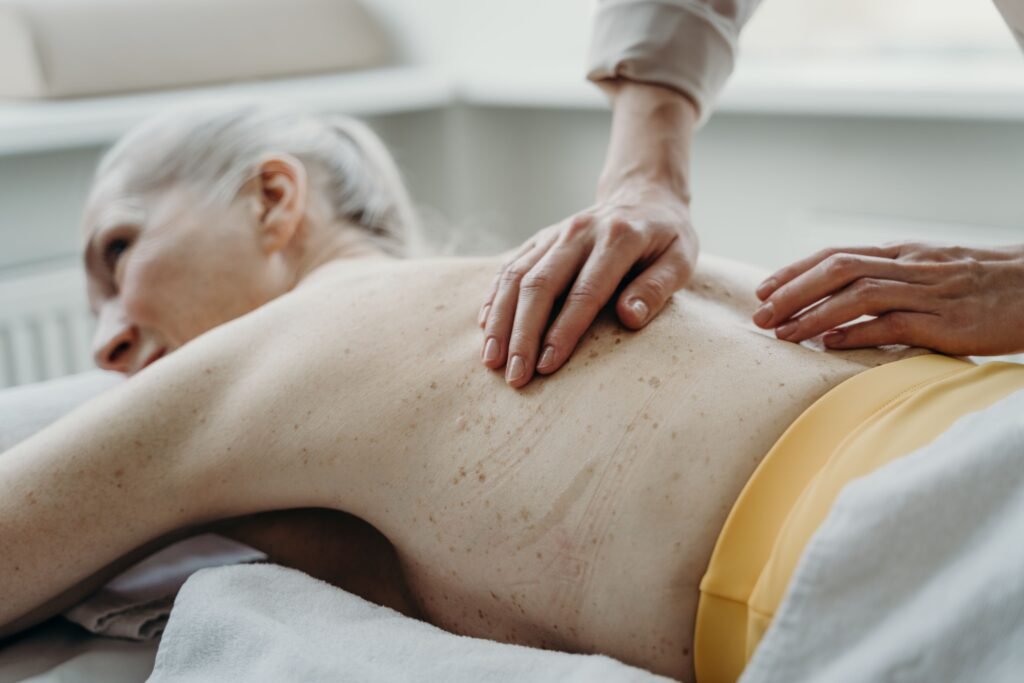 A senior woman enjoying a therapeutic back massage at a spa for ultimate relaxation.