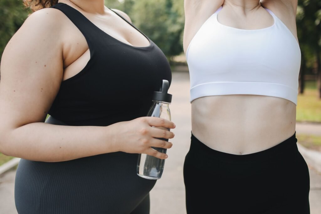 Two diverse women in activewear working out outdoors, promoting body positivity and health.