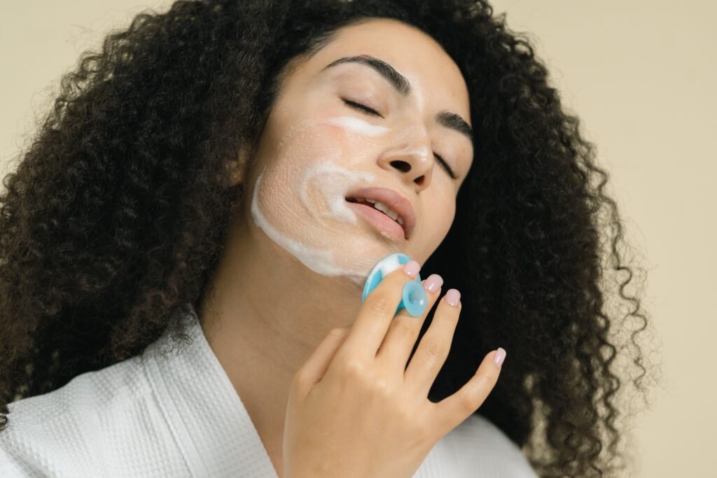 Close-up of a woman applying skincare cream, highlighting self-care and relaxation.